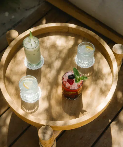 Sélection de cocktails du bar Indie Beach Ramatuelle, servis en terrasse sur table basse bois